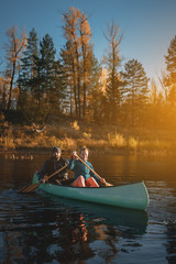 Happy couple in canoe at sunset.