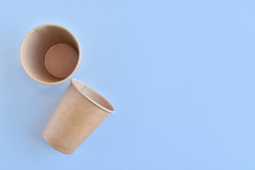 Recycling craft paper cup of coffee to go on neutral background with copy space. Selective focus. Craft cup for hot beverage, takeaway. Disposable cup. Eco package. Cardboard coffee cup