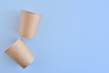 Recycling craft paper cup of coffee to go on neutral background with copy space. Selective focus. Craft cup for hot beverage, takeaway. Disposable cup. Eco package. Cardboard coffee cup