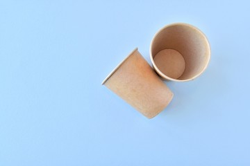Recycling craft paper cup of coffee to go on neutral background with copy space. Selective focus. Craft cup for hot beverage, takeaway. Disposable cup. Eco package. Cardboard coffee cup