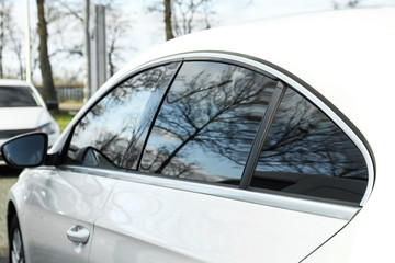 Modern car with tinting foil on window outdoors, closeup