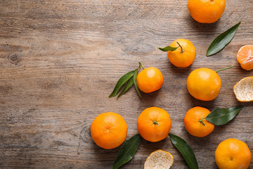 Fresh ripe tangerines on wooden table, flat lay. Space for text