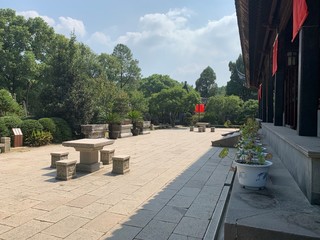 A paved outdoor area with seating in a traditional Asian garden