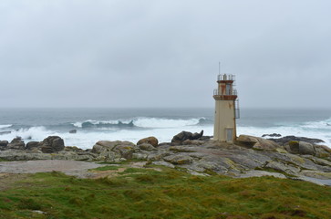 Fototapeta na wymiar Famous Muxia Lighthouse located at Camino de Santiago pilgrimage with storm and waves. Spain.