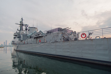 A naval vessel anchored by the river.
