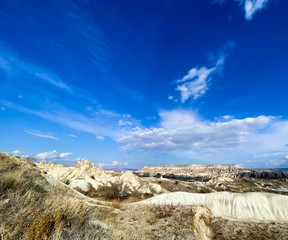 View of a valley filled with ancient rock formations. Blue sky, white clouds. Landscape. Cappadocia, Turkey. 5 november 2019