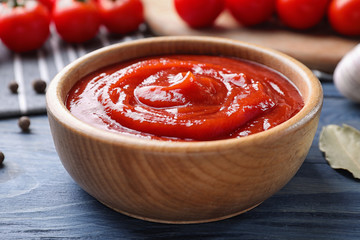Delicious fresh tomato sauce on blue wooden table, closeup