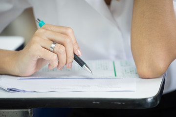high school,university student study.hands holding pencil writing paper answer sheet.sitting lecture chair taking final exam attending in examination classroom.concept scholarship for education abroad