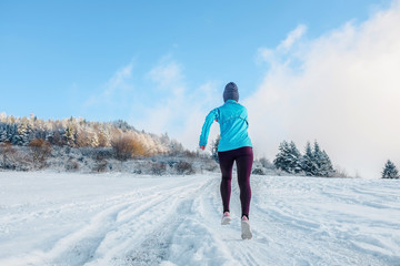 Running woman. Runner on the snow in winter sunny day. Female fi