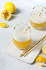 Whiskey sour cocktail - bourbon with lemon juice, sugar syrup and egg white in glass. Vertical orientation.