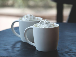 Two white mug of latte with selective focus - Freshly brewed drink - cafe, window and coffee shop