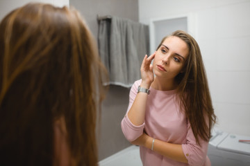woman in bathroom looking at the mirror