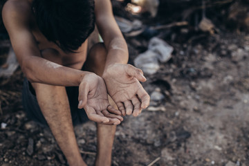 hands poor child or beggar begging you for help sitting at dirty slum. concept for poverty or...