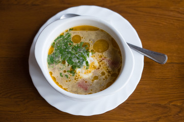 A plate with a red borscht on the table close-up