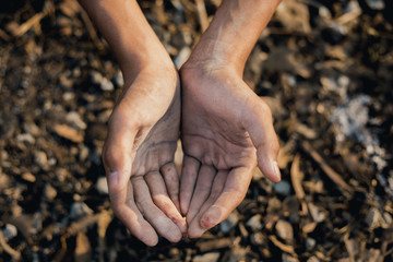 hands poor child or beggar begging you for help sitting at dirty slum. concept for poverty or hunger people,human rights,donate and charity for underprivileged children in third world 