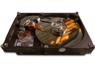 The old IDE hard disk internal components with a beautiful shiny magnetic disk.