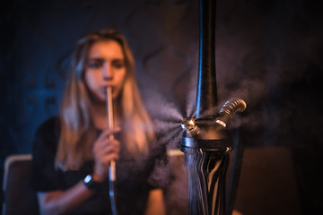 young woman smoking in hookah bar