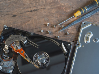 The old IDE hard disk internal components with a beautiful shiny magnetic disk.