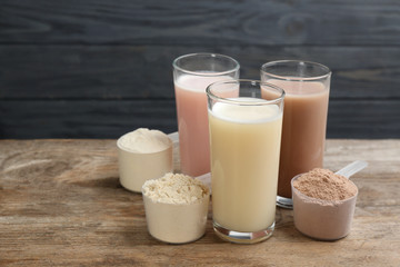 Protein shakes and powder on wooden table