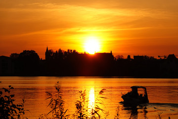 Naklejka premium Motorboot bei Sonnenuntergang