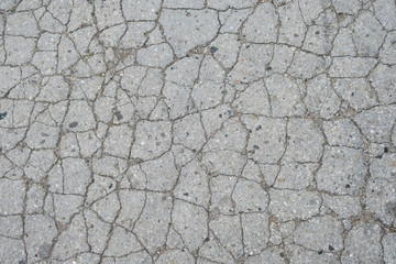 Old road background - surface of grey cracked asphalt texture