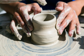 Fototapeta na wymiar Womans hands working of ceramics on potter wheel closeup
