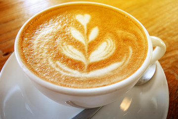 cup of the latte art coffee with warm light