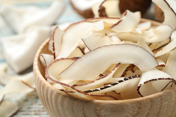 Tasty coconut chips in wooden bowl, closeup