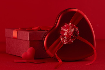 Red surprise gift boxes with ribbon in the shape of heart gifts with love for Valentine's Day or Christmas on scarlet background close up