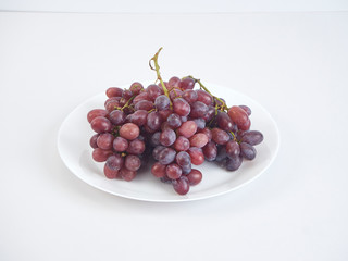 Bunch of grapes on white plate.