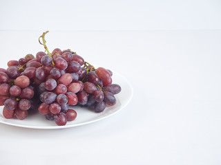 Bunch of grapes on white plate.