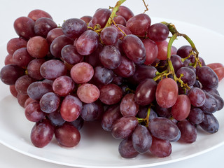 Bunch of grapes on white plate.
