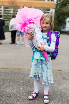 M&auml;dchen im Kleid mit Schult&uuml;te und Schulranzen