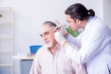 Obraz na płótnie Canvas Male patient with hearing problem visiting doctor otorhinolaryng