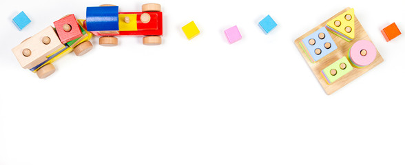 Baby kids toys background. Wooden educational geometric stacking blocks toy, wood train and colorful blocks on white background. Top view, flat lay