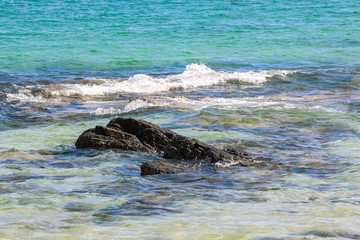 Fototapeta premium Splash of sea water waves hitting the rocky beach