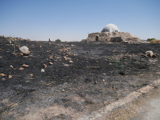 Burned scorched earth after a wildfire on a hill of the citadel of Amman, Jordan