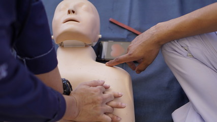 Rescuers teaches how to pump a heart, silicone rubber dummy.                                     