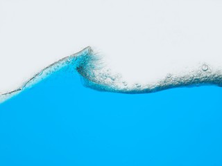 Wave of blue liquid against white background surface view