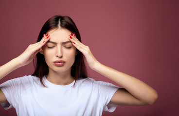 Worried woman closing her eyes holding hands on head having headache after sleepless night.
