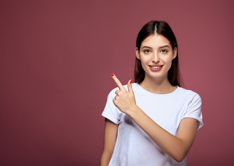 Portrait of Dark-hairedlady smiling in on pink background.