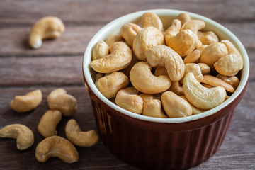 Cashew nut in brown bowl on wooden table