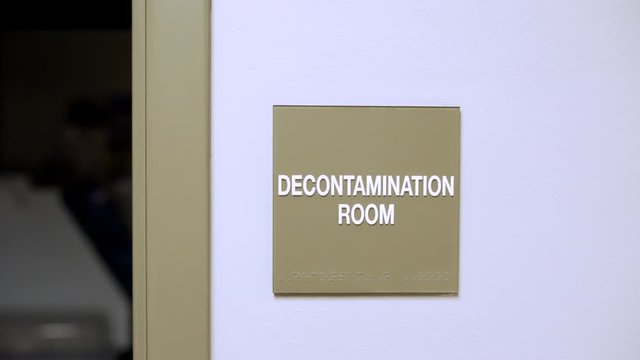 Decontamination room Sign on wall in medical office hospital. slider movement of establishing shot for room inside doctors office.