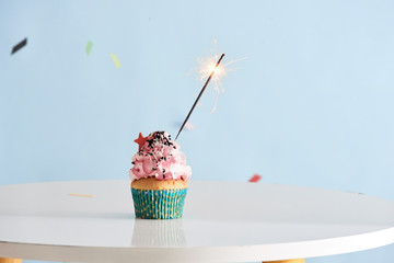 Single sparkler on cupcake blue wal