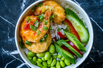 Take Away Healthy Buddha Bowl with Shrimp, Edamame Beans, Cucumber and Basmati Rice / Poke Bowl in Plastic Box Package or Container.