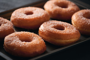 Donuts with sugar on a tray in a bar