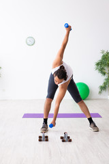 Young handsome man doing sport exercises indoors