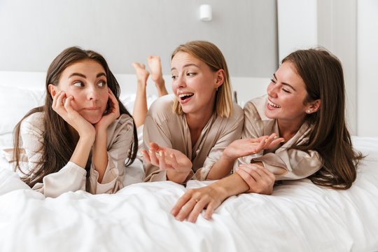 Three cheerful girls friends wearing dressing gowns