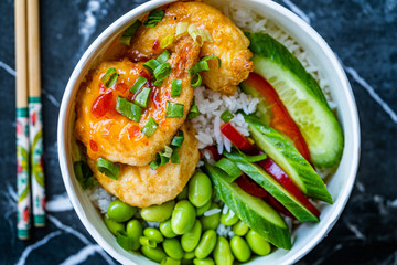 Take Away Healthy Buddha Bowl with Shrimp, Edamame Beans, Cucumber and Basmati Rice / Poke Bowl in Plastic Box Package or Container.
