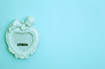 Soft Focus, Cement Picture Frame In a heart shape and cupids placed on a beautiful blue background